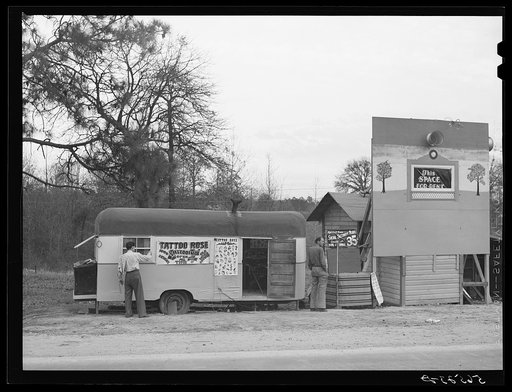 Signs and trailer with tattoo artist on highway near Fort Beauregard.  Alexandria, Louisiana