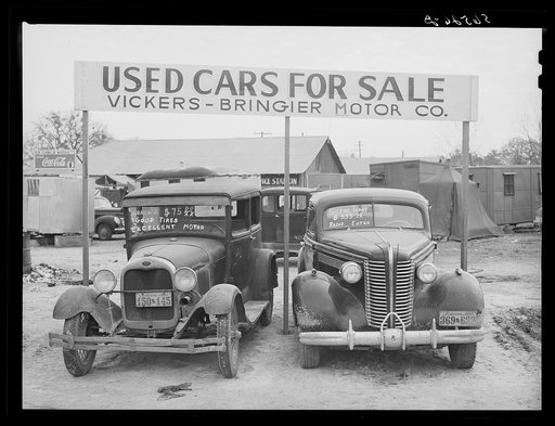 Used cars for sale with signs and prices at service station on main highway near Alexandria, Louisiana