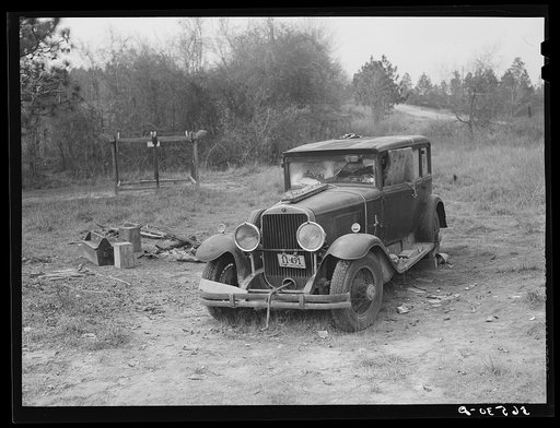 Close-up of car from Mississippi used for sleeping as well as shelter and traveling. Evidences of cooking outdoors are beside it. On highway near Camp Livingston, Alexandria, Louisiana