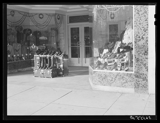 Untitled photo, possibly related to: Trunks and boots in front of store window on main street. Columbus, Georgia