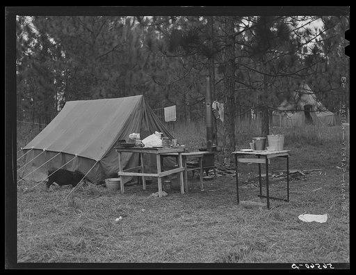 Camp Livingston construction workers' tents on government property, rent free, near Alexandria, Louisiana. Most of the people cook outdoors, have no sanitary facilities and haul water from a nearby church faucet