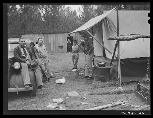 Untitled photo, possibly related to: Camp Livingston construction worker cooking outdoors in front of shacks which they have built themselves out of lumber they purchased or found nearby. These are along the main highway on government property so they do not have to pay rent. Water is hauled from a 