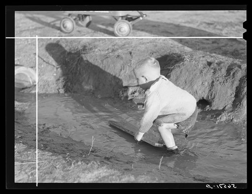 Child playing in front of his home on Milstead Avenue about five miles outside of Columbus, Georgia. Near Fort Benning. His father is at Fort Benning