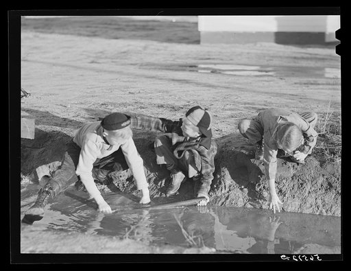 Untitled photo, possibly related to: Children of Army men's families on Milstead Avenue playing in water in front of their new homes five miles outside of Columbus, Georgia