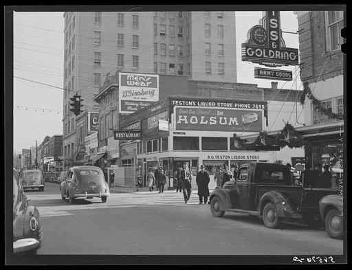 Untitled photo, possibly related to: Corner building in center of Alexandria showing signs and advertising Army and military wearing apparel and goods