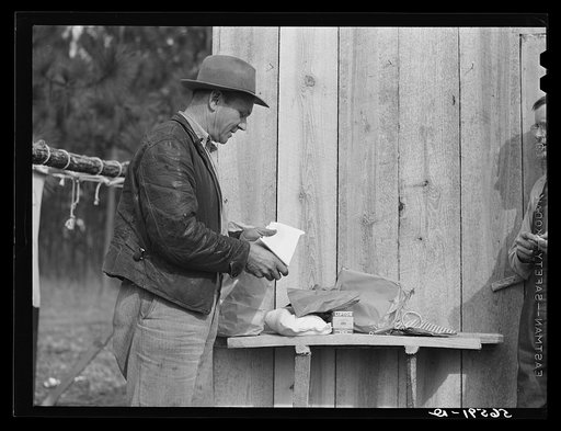 Untitled photo, possibly related to: Mr. R. Jones in front of new shack built on government property near Camp Livingston with supplies he purchased in town--sugar, tea, strainers, dish towels, linoleum for shelves, etc. Alexandria, Louisiana