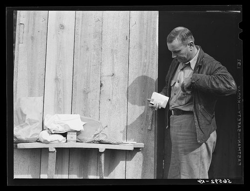 Mr. R. Jones in front of new shack built on government property near Camp Livingston with supplies he purchased in town--sugar, tea, strainers, dish towels, linoleum for shelves, etc. Alexandria, Louisiana