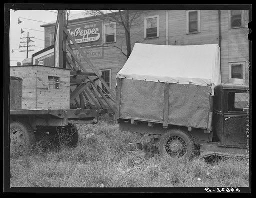 Converted canvas-topped truck (self-built), used by six construction workers for the past two months, in which they sleep in three shifts; parked in on highway to Camp Livingston. Alexandria, Louisiana