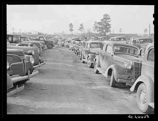 Parked cars off side of highway near entrance to Camp Claiborne all belonging to construction workers, this roadside congestion extends for over a mile. Louisiana