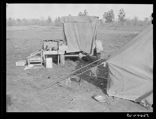 Tent and farm truck used for sleeping and general housing by construction workers off highway near Camp Claiborne. They cook out of doors and have no sanitary conveniences. Alexandria, Louisiana