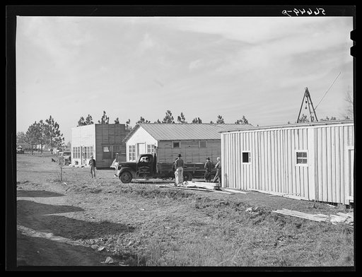 Cars of construction workers at Camp Claiborne, Alexandria, Louisiana. New buildings on highway at Camp Claiborne. Cabins, sleeping quarters, etc., being built by private interest for construction workers. Louisiana