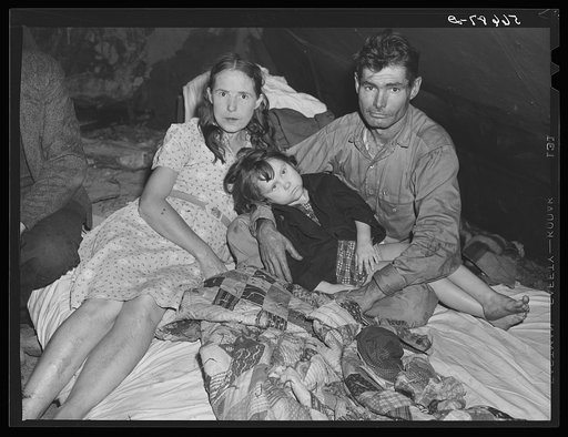 Construction worker with wife and neighbor's child in tent home near Alexandria, Louisiana. Ten men, two women, and two children live here