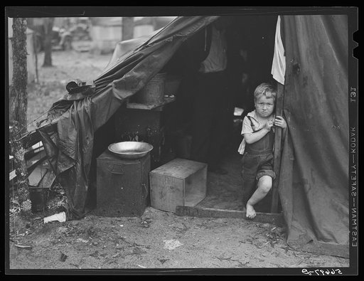 Child of construction worker in doorway of tent home near Alexandria, Louisiana. Ten men, two women, and two children live here