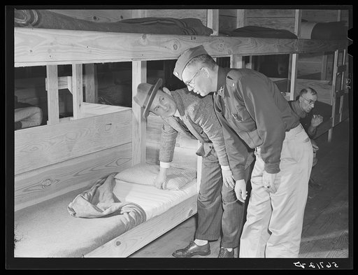 Major Cooke and Mr. O.E. Miller, personnel director for the construction company, inspecting beds inside barracks where construction workers live at Camp Blanding, Florida