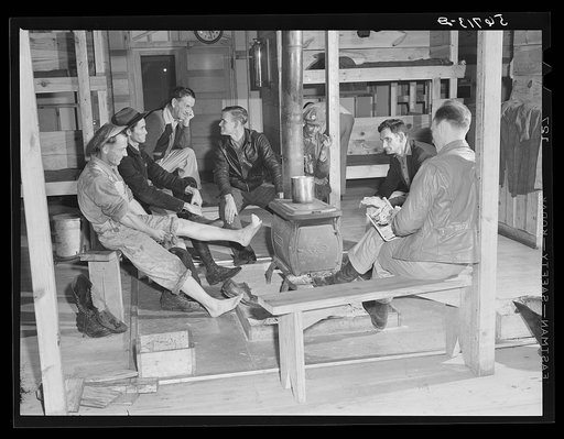 Construction workers around stove after work in new craftsmen's barracks. Camp Blanding, Florida