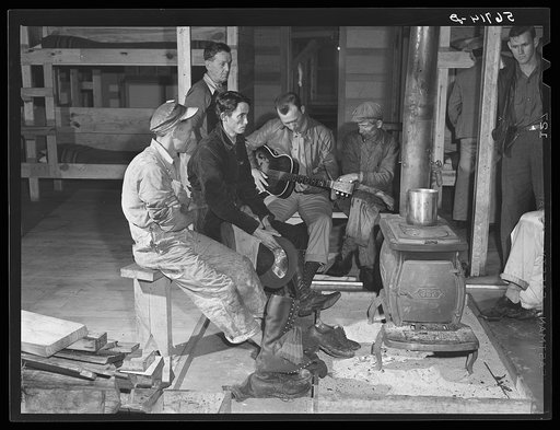 Construction workers around stove after work in new craftsmen's barracks. Camp Blanding, Florida
