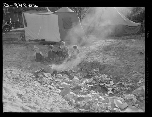 Construction workers' children playing around garbage and rubbish heap in back of their tents. Near Camp Livingston, Alexandria, Louisiana