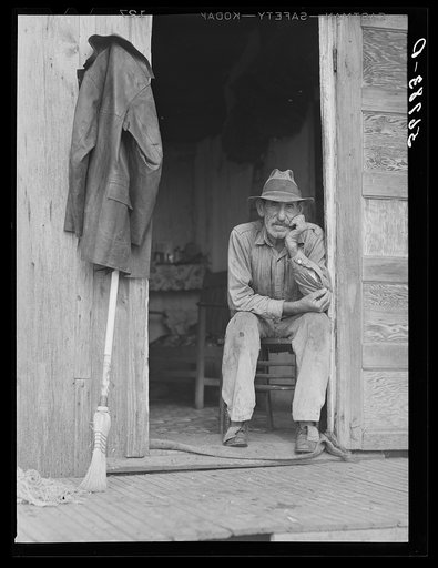 Spanish muskrat trapper in doorway of his marsh camp. Delacroix Island, Saint Bernard Parish, Louisiana
