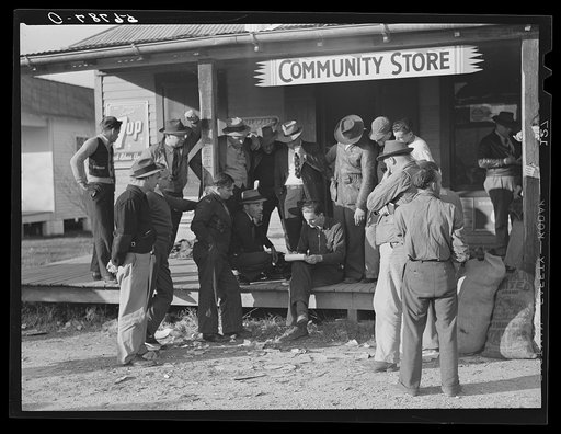 Untitled photo, possibly related to: Spanish trappers and fur buyers waiting around while muskrats are being graded during auction sale on porch of community store. Saint Bernard, Louisiana
