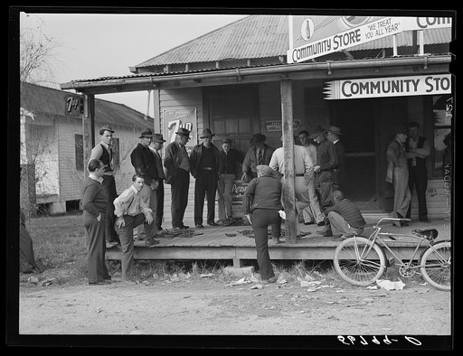 Spanish trappers and fur buyers waiting around while muskrats are being graded during auction sale on porch of community store. Saint Bernard, Louisiana