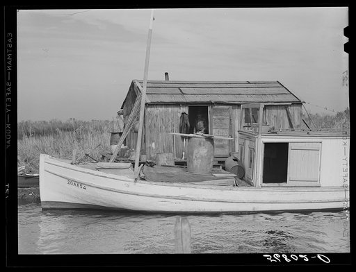 Untitled photo, possibly related to: Spanish trappers' camp in the marshes. In the small "piroque" (or canoe) he can go up the very narrow and shallow bayous; the large boat he uses for fishing, going to the island to sell his muskrat pelts, and bringing back supplies. Delacroix Island, Saint Bernar
