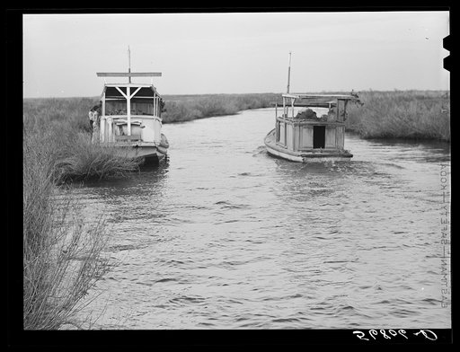 Untitled photo, possibly related to: A Spanish muskrat trapper's boat in a bayou by his marsh camp. He uses this large boat in other seasons for fishing and shrimping. Delacroix Island, Saint Bernard Parish, Louisiana