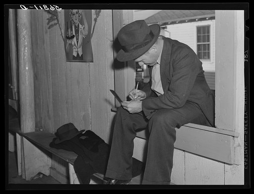 Fur buyer figuring out his bid on the next lot of muskrat pelts. The auction sale is held in a dance hall on Delacroix Island, Saint Bernard Parish, Louisiana