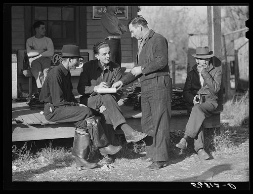 Fur buyer handing FSA (Farm Security Administration) supervisor his bid on the next lot of muskrats. The auction sale is being held on the porch of the community general store in Saint Bernard, Louisiana