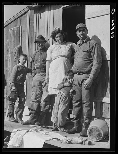 Spanish muskrat trapper with his father, his wife and their two children, in front of their camp in the marshland. Delacroix Island, Saint Bernard Parish, Louisiana