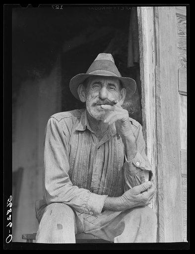 Spanish muskrat trapper in doorway of his marsh camp. Delacroix Island, Saint Bernard Parish, Louisiana