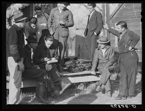 Spanish trappers and fur buyers crowd around FSA (Farm Security Administration) supervisor as he opens and reads the bids on that lot of muskrats. The auction sale is on porch of community store, Saint Bernard, Louisiana