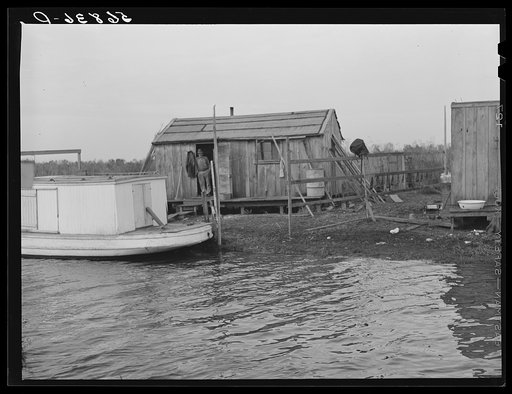 Untitled photo, possibly related to: Spanish trapper's camp in the marshes. In the small "piroque"(or canoe) he can go up the very narrow and shallow bayous; the large boat he uses for fishing, going to the island to sell his muskrat pelts, and bringing back supplies. Delacroix Island, Saint Bernard