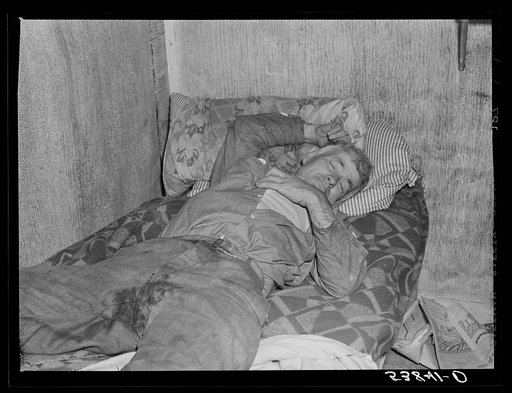 Spanish muskrat trapper on his camp bed after too much whiskey and red wine. Delacroix Island, Saint Bernard Parish, Louisiana