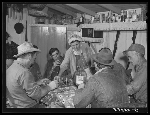 Spanish muskrat trappers drinking wine and playing "cache," a form of poker, in their camp in the marshes. Delacroix Island, Saint Bernard Parish, Louisiana