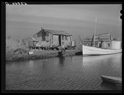 Untitled photo, possibly related to: Spanish trappers' camp in the marshes. In the small "piroque" (or canoe) he can go up the very narrow and shallow bayous; the large boat he uses for fishing, going to the island to sell his muskrat pelts, and bringing back supplies. Delacroix Island, Saint Bernar