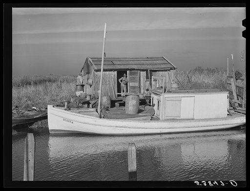 Spanish trappers' camp in the marshes. In the small "piroque" (or canoe) he can go up the very narrow and shallow bayous; the large boat he uses for fishing, going to the island to sell his muskrat pelts, and bringing back supplies. Delacroix Island, Saint Bernard Parish, Louisiana.