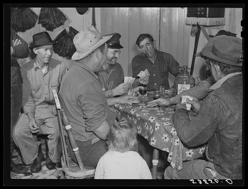 Spanish muskrat trappers drinking wine and playing "cache," a form of poker, in their camp in the marshes. Delacroix Island, Saint Bernard Parish, Louisiana
