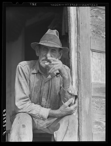 Spanish muskrat trapper in doorway of his marsh camp. Delacroix Island, Saint Bernard Parish, Louisiana