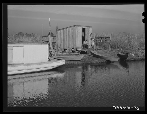 Spanish trapper's camp in the marshes. In the small "piroque" (or canoe) he can go up the very narrow and shallow bayous; the large boat he uses for fishing, going to the island to sell his muskrat pelts, and bringing back supplies. Delacroix Island, Saint Bernard Parish, Louisiana
