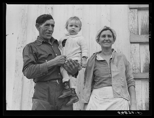 Spanish muskrat trapper, his wife and their adopted child by their marsh camp. Delacroix Island, Saint Bernard Parish, Louisiana