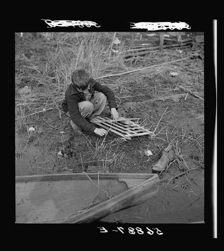 Untitled photo, possibly related to: Spanish trapper's son setting the trap which he made to catch birds by his camp in the marshes near Delacroix Island, Louisiana