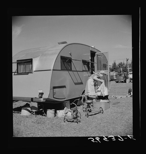 One of the modern trailers parked in Sarasota trailer park, Sarasota, Florida. Mother is doing the family washing