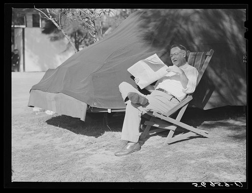 Reading newspaper. Sarasota trailer park, Sarasota, Florida