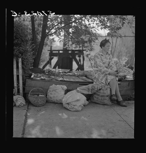 Mountain woman with groceries and supplies resting by roadside. Jackson, Breathitt County, Kentucky