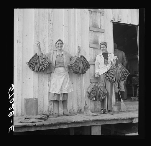 Spanish trapper's wife and sister-in-law holding dried muskrat skins in front of their camp in the marshes near Delacroix Island, Louisiana