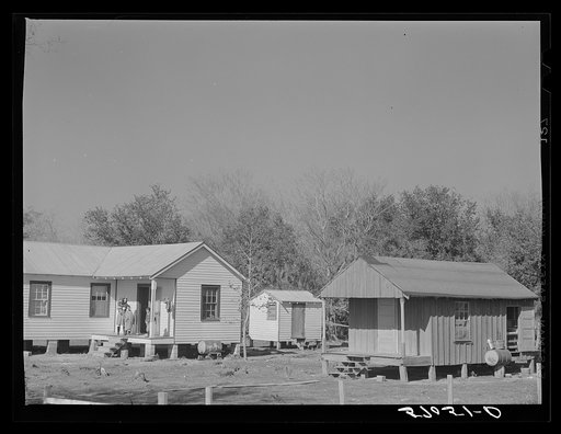 Old home belonging to Spanish muskrat trapper with the new one purchased with the help of a FSA (Farm Security Administration) loan. On Delacroix Island, Louisiana. See general caption number one