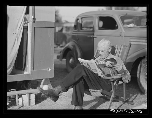 Reading magazine beside his trailer home. Sarasota trailer park, Sarasota, Florida