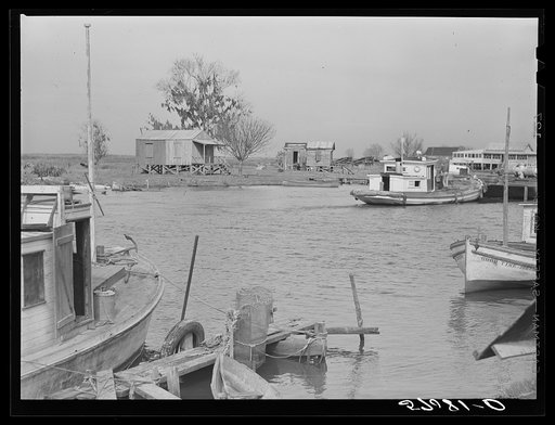 Trappers' and fishermen's boats and homes along the bayou. Delacroix Island, Louisiana
