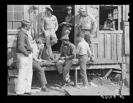 Migratory laborers playing checkers in front of juke joint during slack season for vegetable pickers. Belle Glade, Florida