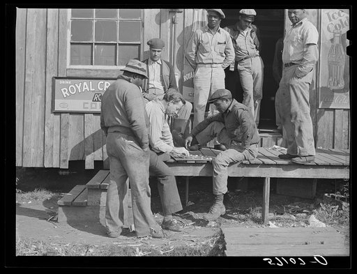 Untitled photo, possibly related to: Migratory laborers playing checkers in front of juke joint during slack season for vegetable pickers. Belle Glade, Florida